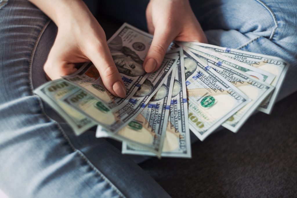 A woman sitting down and showing the real cash method money