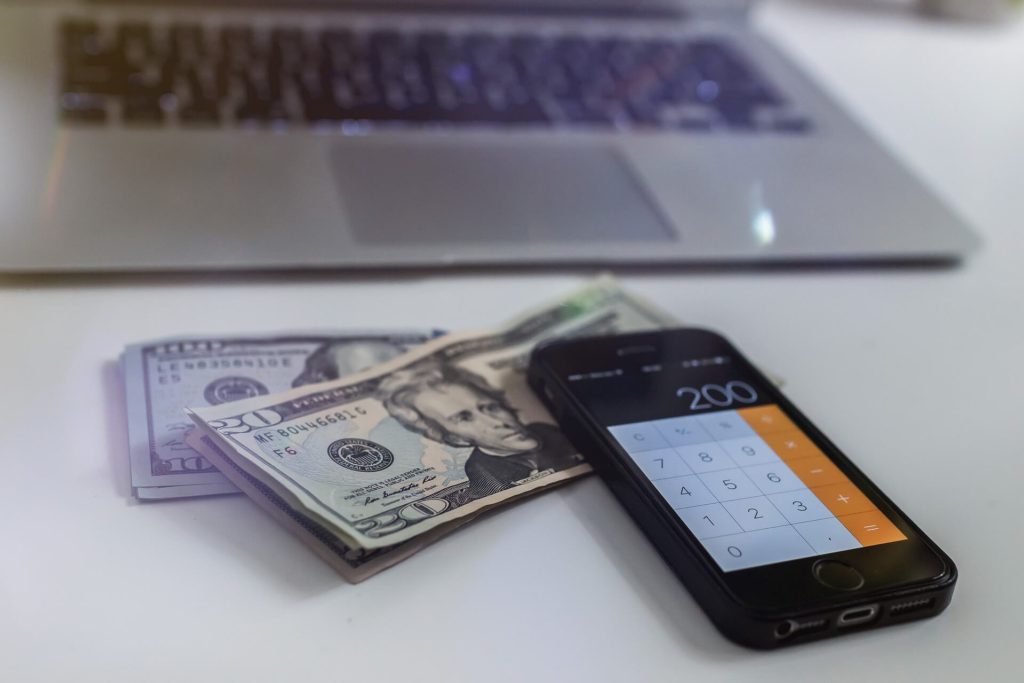 Image of Cash on a table and a laptop