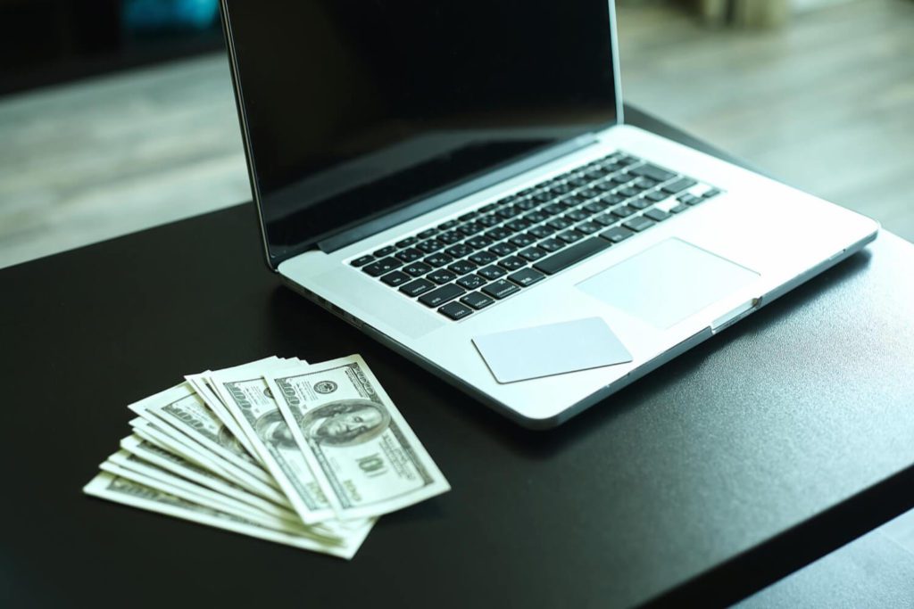 A laptop with bunch of money