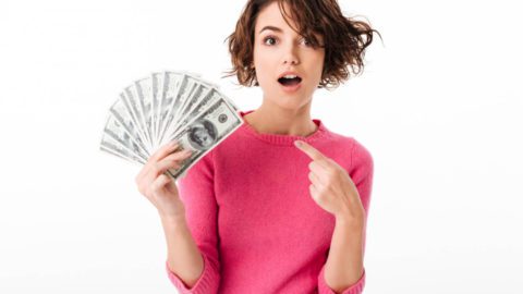 A woman pointing to a lot of money in shock-Maximizing gig job potential