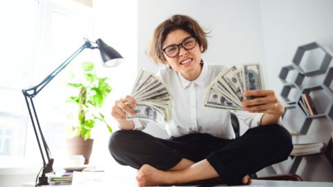 A woman showing off money:Explore lucrative opportunities in content creation. Tap into the $21B market with expert strategies and insights.