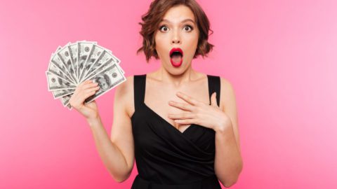 A woman holding a bunch of money in shock. Overcome the control of the Central Bank Digital Currency and start making money like her