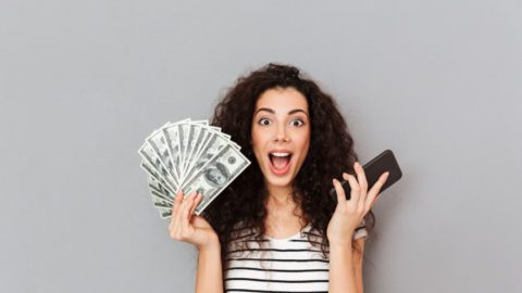 A woman showing making money on the phone with Scramble